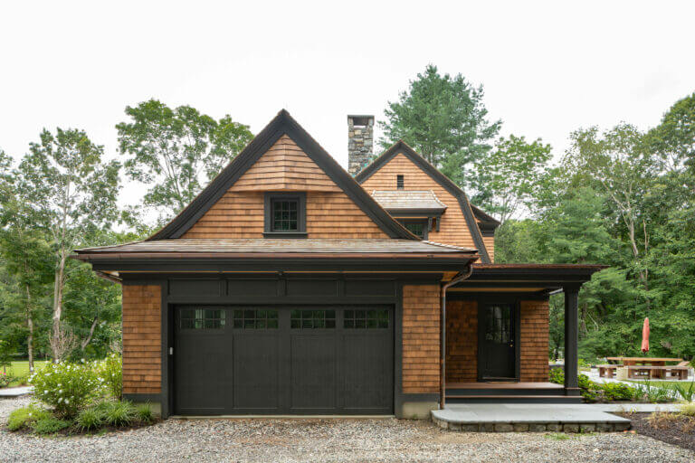 Garage Door and side door view of a custom designed and built barn-like residential home