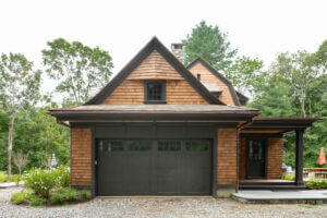 Garage Door and side door view of a custom designed and built barn-like residential home