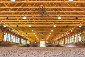 Well Lit Indoor Riding Arena with wood ceiling and walls.