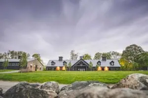 A custom Horse Barn by Old Town Barns lit up at dusk